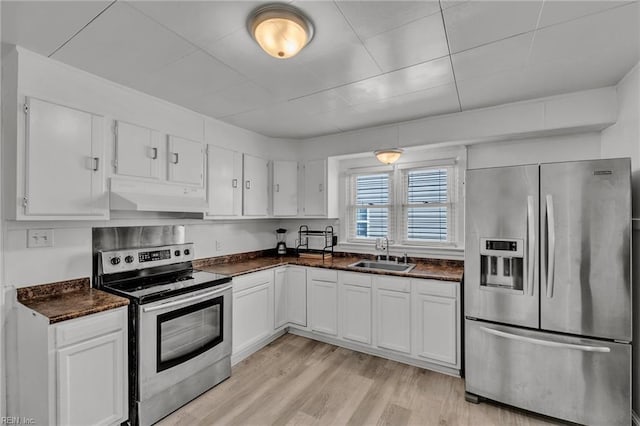 kitchen with stainless steel appliances, sink, light hardwood / wood-style flooring, and white cabinets