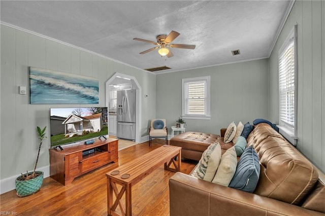 living room featuring crown molding, ceiling fan, and hardwood / wood-style flooring