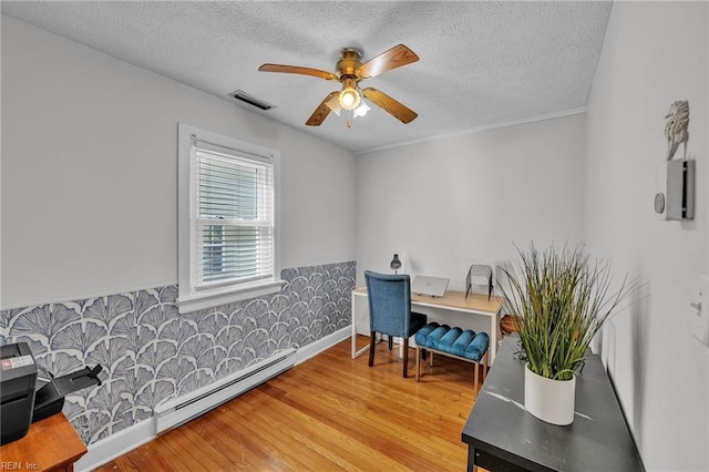 interior space featuring ceiling fan, hardwood / wood-style floors, a textured ceiling, and a baseboard heating unit