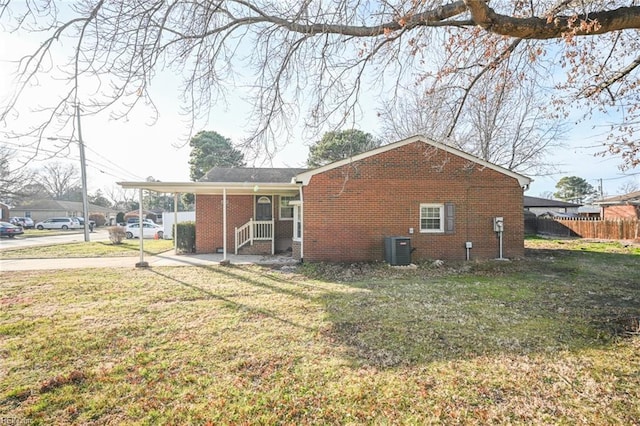 rear view of property featuring central AC and a yard