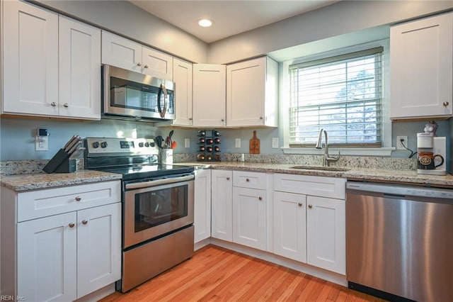 kitchen with white cabinetry, sink, and stainless steel appliances