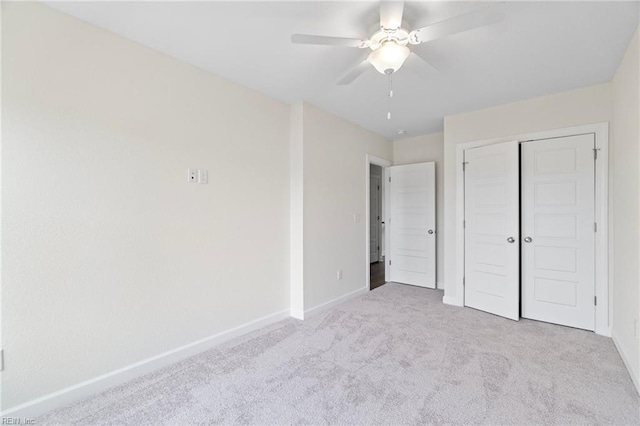 unfurnished bedroom featuring ceiling fan, a closet, and light carpet