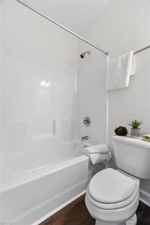 bathroom featuring hardwood / wood-style flooring, bathing tub / shower combination, and toilet