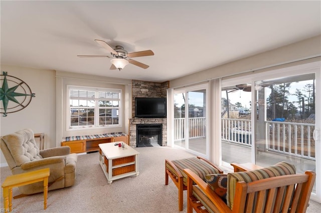 living room with light carpet, a wealth of natural light, a fireplace, and ceiling fan