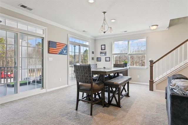 carpeted dining room with crown molding