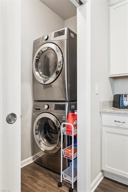 washroom featuring dark wood-type flooring and stacked washing maching and dryer