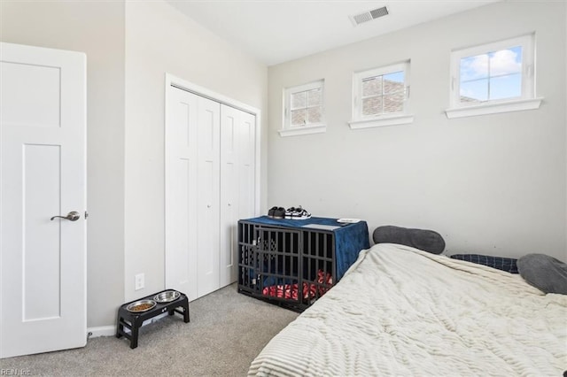 bedroom featuring light colored carpet and a closet