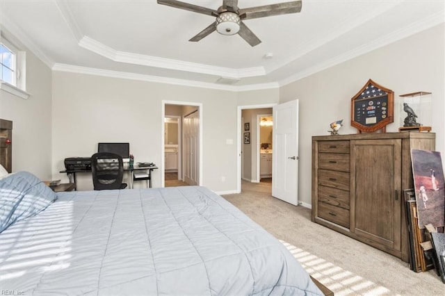 carpeted bedroom with crown molding, ceiling fan, connected bathroom, and a tray ceiling