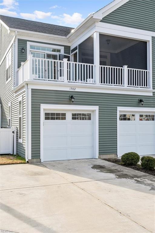 view of side of home with a garage and a balcony