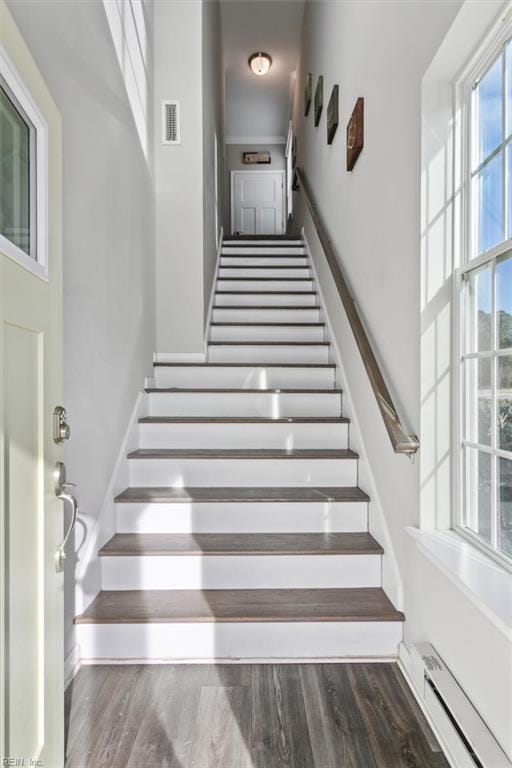 stairs featuring baseboard heating and hardwood / wood-style floors