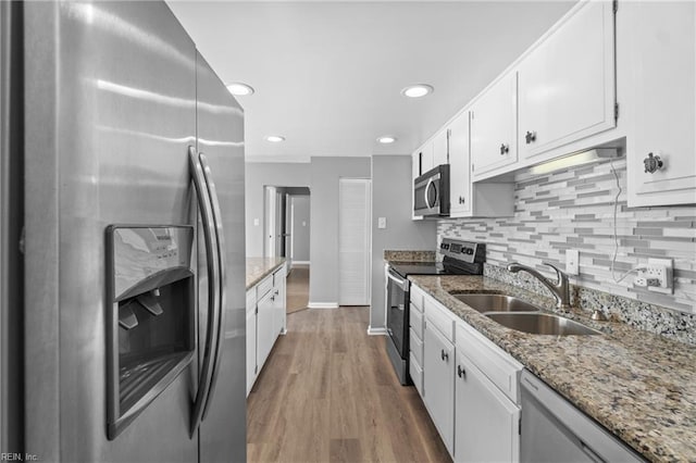 kitchen featuring light stone countertops, white cabinetry, appliances with stainless steel finishes, and sink