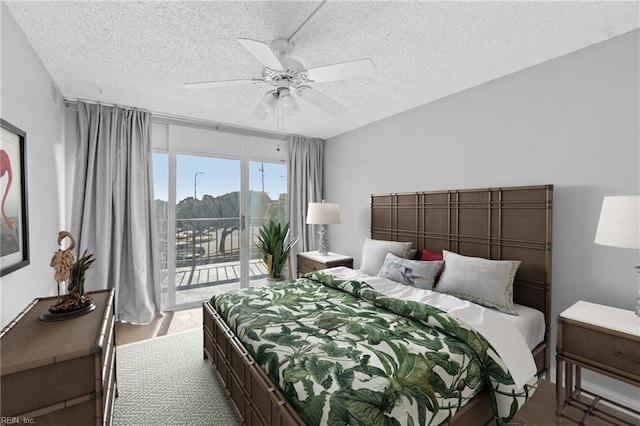 bedroom featuring access to exterior, a textured ceiling, ceiling fan, and light wood-type flooring