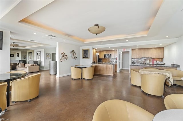 living room featuring sink and a raised ceiling