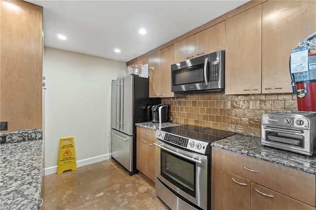 kitchen with appliances with stainless steel finishes, dark stone counters, and decorative backsplash