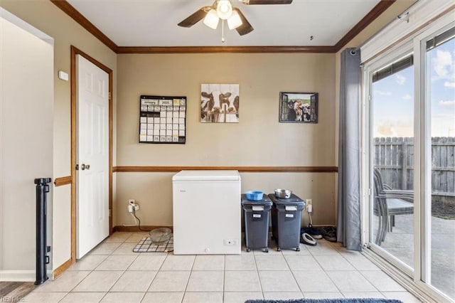 clothes washing area featuring light tile patterned floors, a wealth of natural light, ornamental molding, and ceiling fan