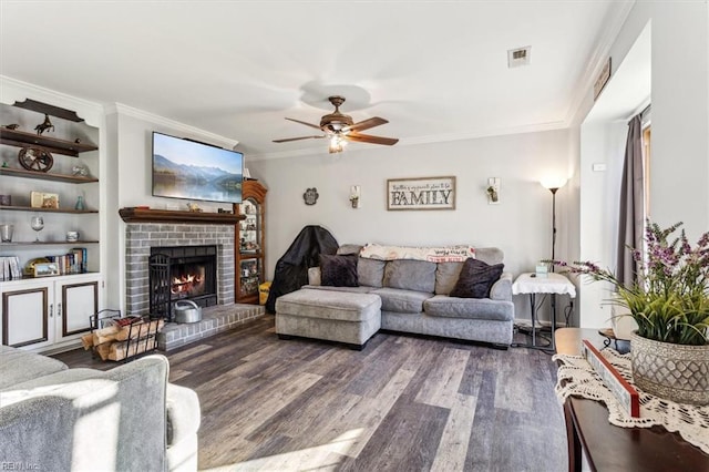 living room featuring ornamental molding, ceiling fan, a fireplace, and dark hardwood / wood-style flooring