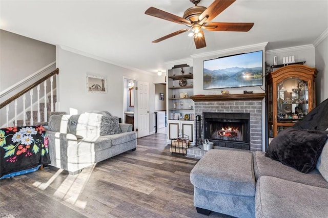 living room featuring ornamental molding, a brick fireplace, dark hardwood / wood-style floors, and ceiling fan