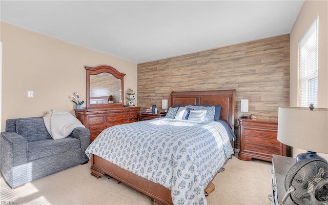 bedroom with light colored carpet and wood walls