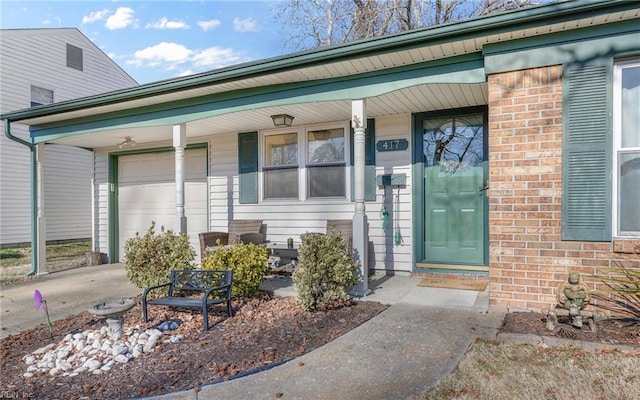 view of exterior entry with a garage and a porch