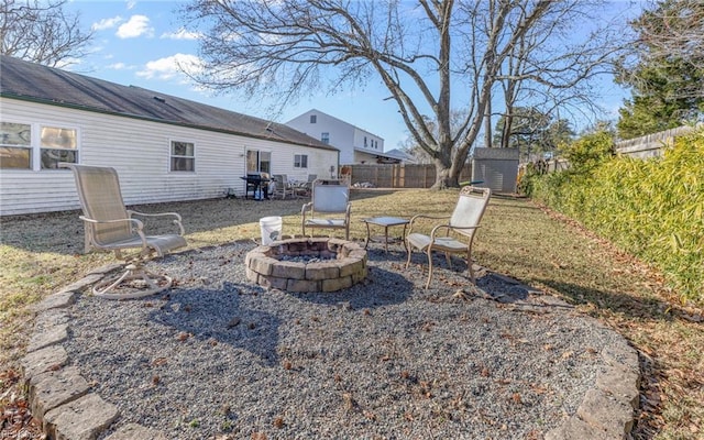 view of yard featuring a storage shed and an outdoor fire pit