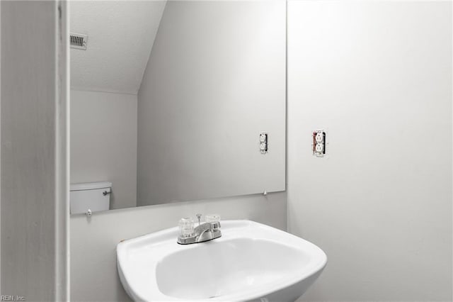 bathroom featuring sink, a textured ceiling, and toilet