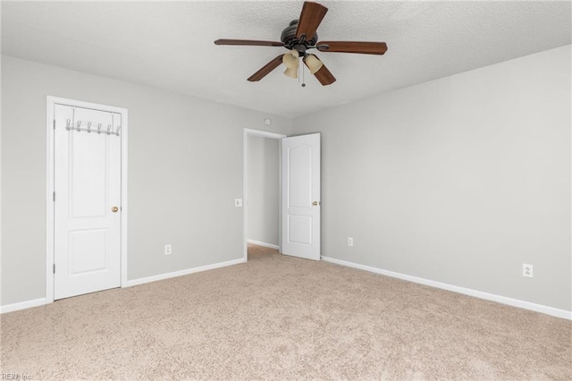 carpeted empty room featuring a textured ceiling and ceiling fan