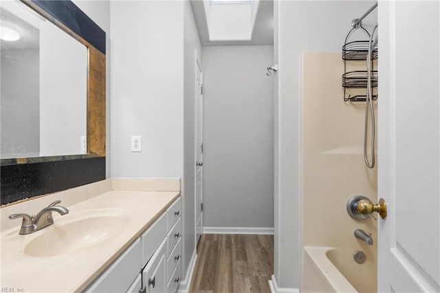 bathroom featuring hardwood / wood-style flooring, vanity, and washtub / shower combination