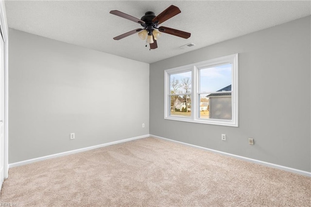 carpeted spare room featuring ceiling fan and a textured ceiling