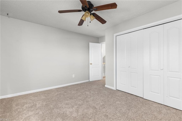 unfurnished bedroom with light carpet, a textured ceiling, a closet, and ceiling fan