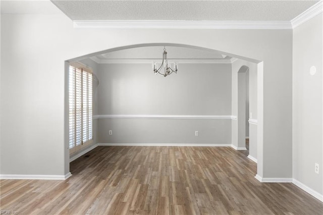 unfurnished dining area with crown molding, a chandelier, hardwood / wood-style floors, and a textured ceiling