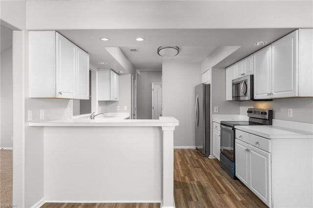 kitchen with white cabinetry, dark hardwood / wood-style flooring, kitchen peninsula, and appliances with stainless steel finishes