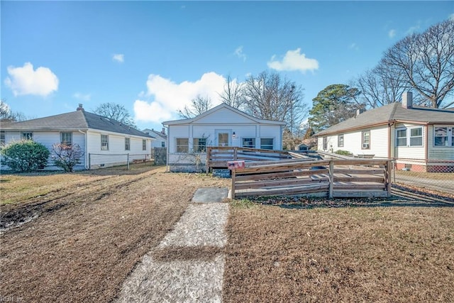 view of front facade featuring a wooden deck and a front yard