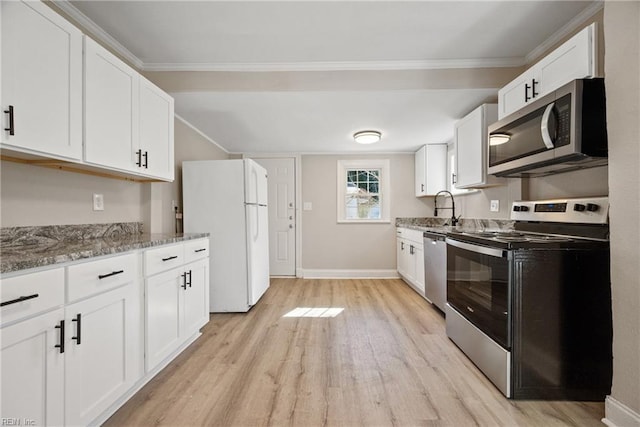 kitchen featuring stone countertops, sink, white cabinets, stainless steel appliances, and light wood-type flooring