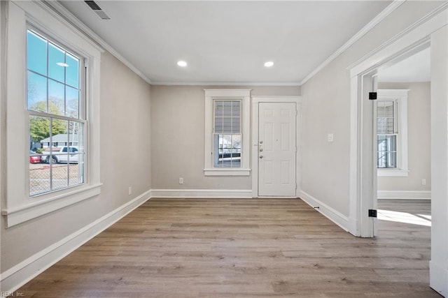 entrance foyer featuring ornamental molding and light hardwood / wood-style floors