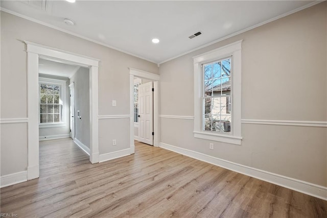 unfurnished room featuring a healthy amount of sunlight, ornamental molding, and light hardwood / wood-style floors