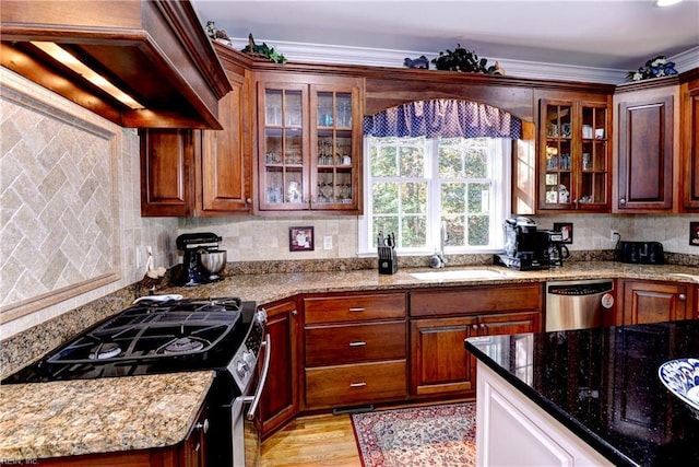 kitchen featuring light stone counters, sink, backsplash, and stainless steel appliances