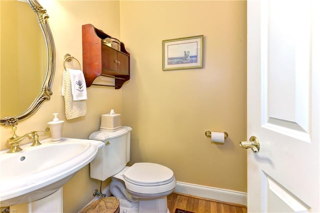 bathroom with hardwood / wood-style flooring, sink, and toilet