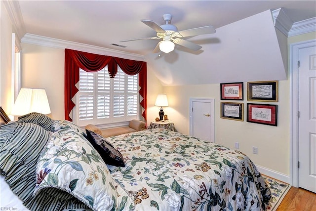 bedroom featuring ornamental molding, lofted ceiling, hardwood / wood-style floors, and ceiling fan