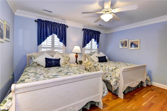 bedroom featuring hardwood / wood-style flooring, ornamental molding, and ceiling fan