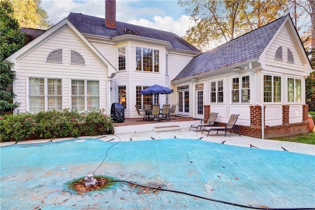 back of house featuring a covered pool