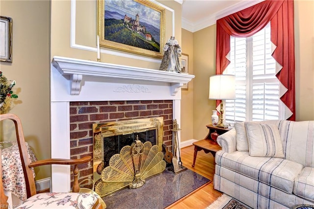 living room with hardwood / wood-style flooring, ornamental molding, a healthy amount of sunlight, and a fireplace