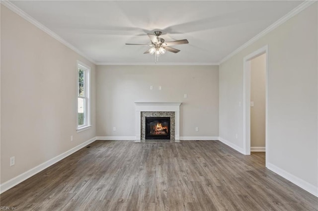 unfurnished living room with ornamental molding, baseboards, and wood finished floors