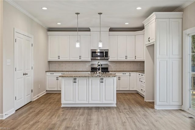 kitchen featuring stainless steel appliances, light wood-type flooring, white cabinetry, and crown molding