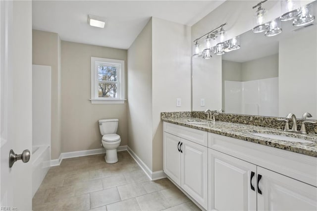 bathroom featuring baseboards, a sink, toilet, and tile patterned floors