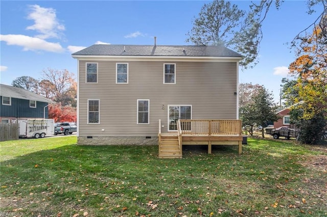 back of property with a yard, crawl space, a wooden deck, and fence