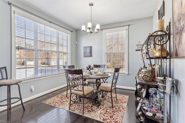 dining space featuring dark hardwood / wood-style floors and a notable chandelier