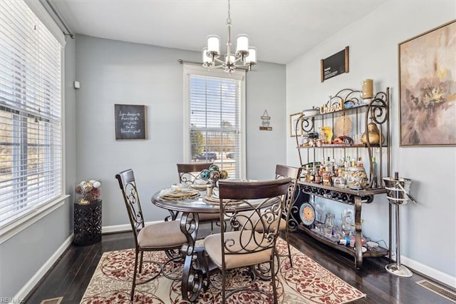 dining space featuring an inviting chandelier and dark hardwood / wood-style floors