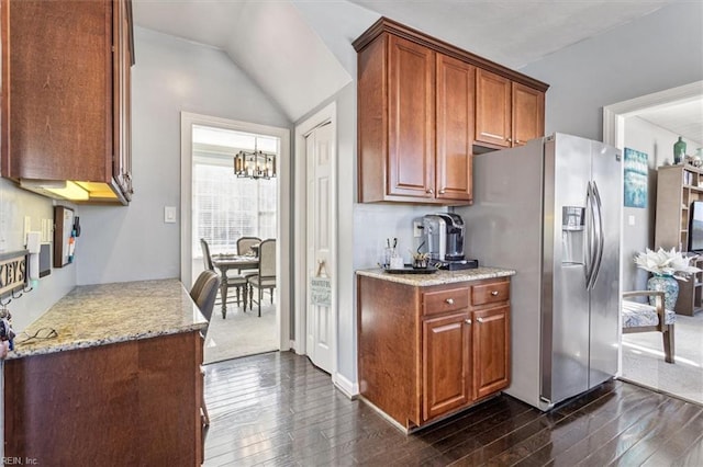 kitchen featuring light stone countertops, dark wood-type flooring, an inviting chandelier, and stainless steel fridge with ice dispenser