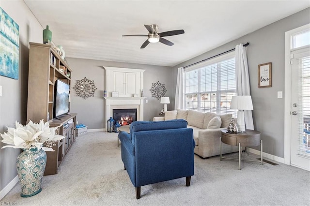 carpeted living room with ceiling fan