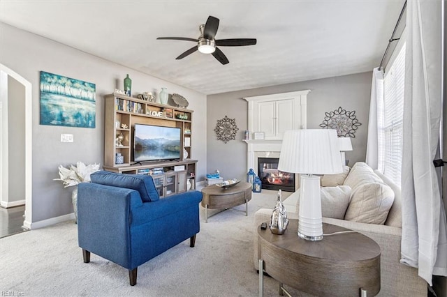 carpeted living room with ceiling fan and a multi sided fireplace